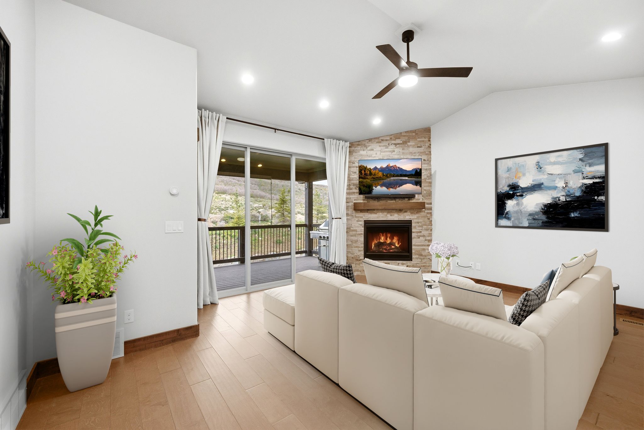 Living space featuring a stone-faced fireplace with a wood mantel, vaulted ceiling, recessed lighting, and wood-finish flooring