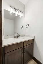 Granite-style countertop with an undermount sink, dark wood-finish vanity, and matte black fixtures
