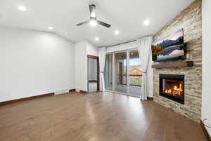 Living space featuring a stone-clad fireplace with a wood mantel, wood-finish flooring, and recessed lighting
