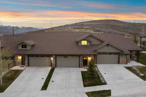 Multi-unit structure featuring a neutral-toned exterior with stone accents and multiple attached garages