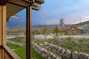 Covered porch with exposed wood beams framing mountain scenery