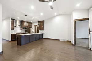 Open-concept kitchen and living area featuring wood-finish flooring, recessed lighting, and a ceiling fan