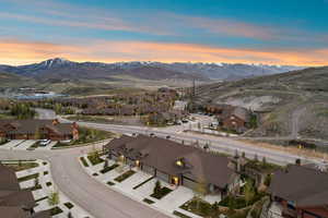 Aerial perspective showcasing a residential development with mountain backdrops and a network of paved roads