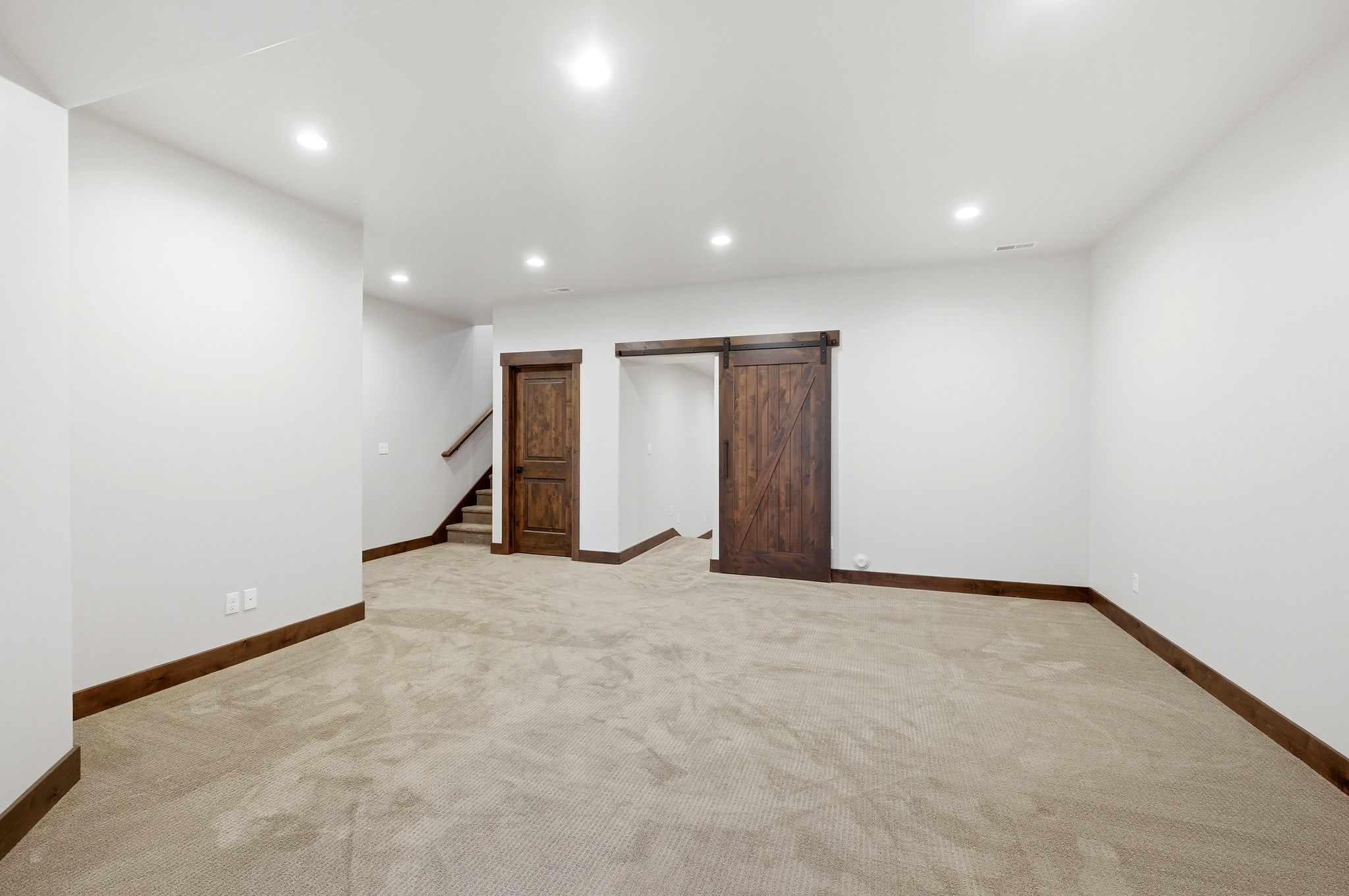 Spacious room featuring neutral carpet flooring, recessed lighting, and white walls