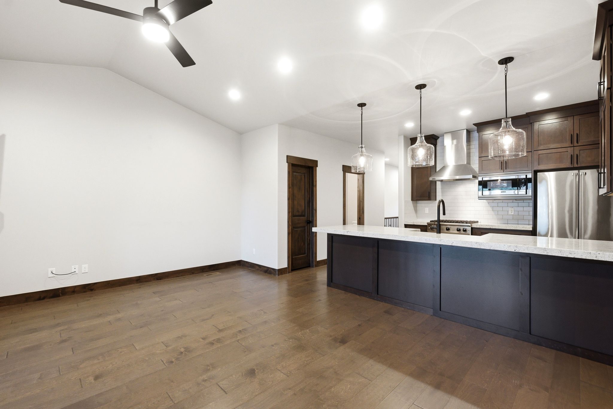 Open-concept living space with wood-finish flooring and a vaulted ceiling