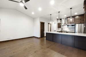 Open-concept living space with wood-finish flooring and a vaulted ceiling