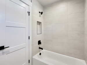 White tub and shower combination with matte black fixtures