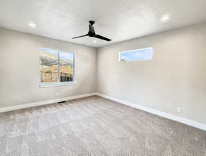 Spacious room featuring neutral carpeting, a contemporary black ceiling fan, and recessed lighting