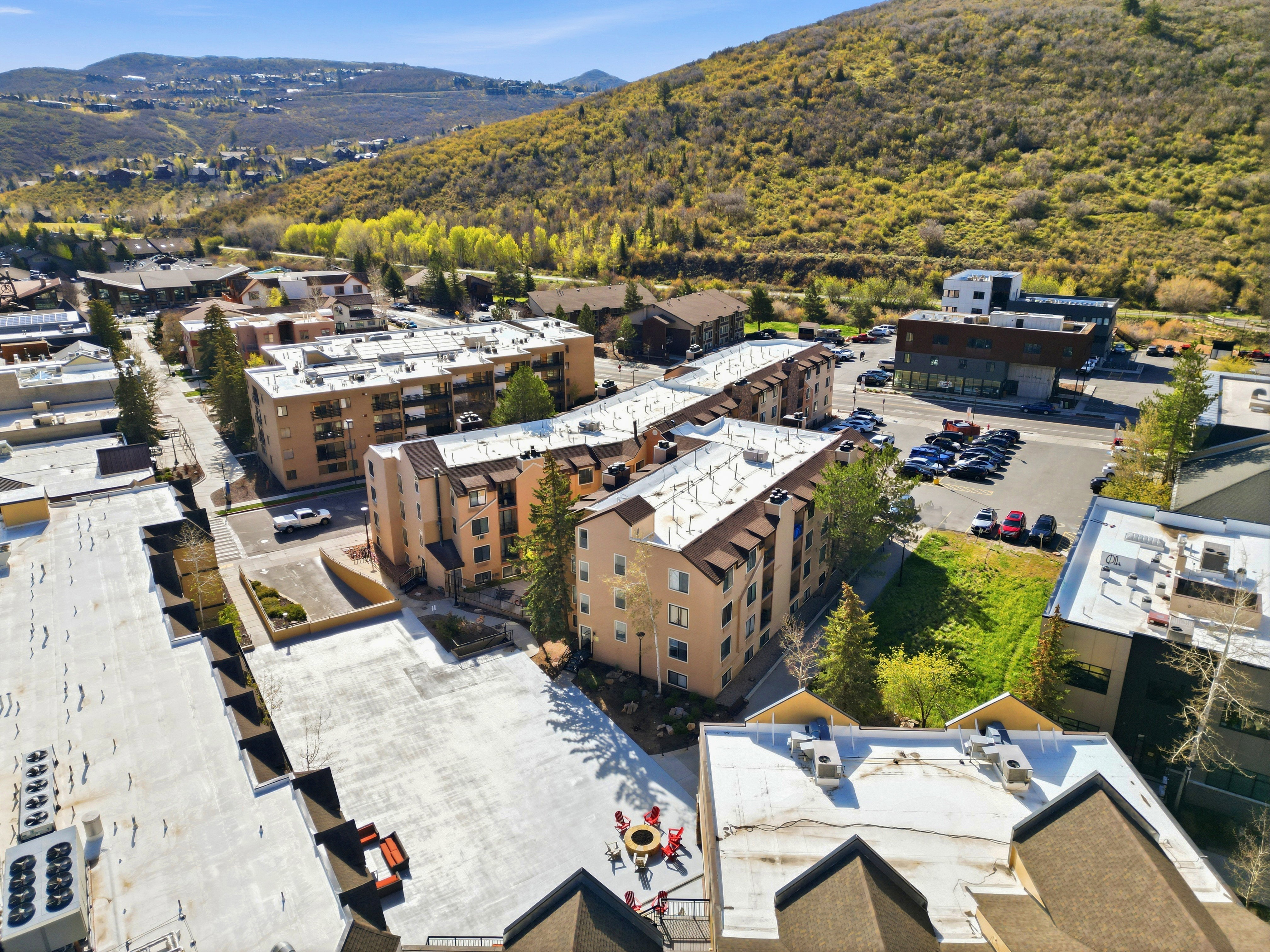 Multi-story buildings with balconies set against a mountainous backdrop