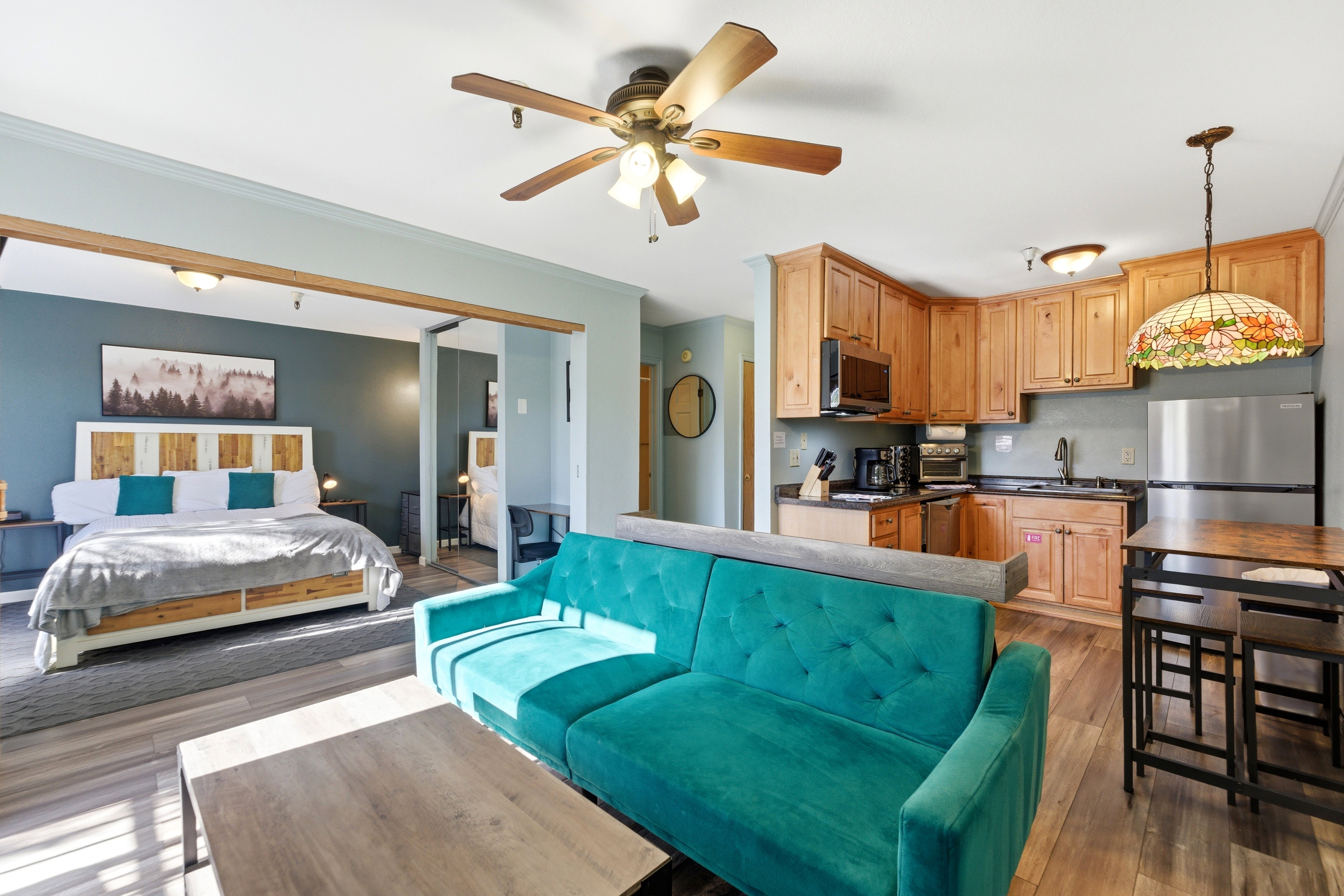 Open-concept living area featuring wood-finish flooring and a ceiling fan