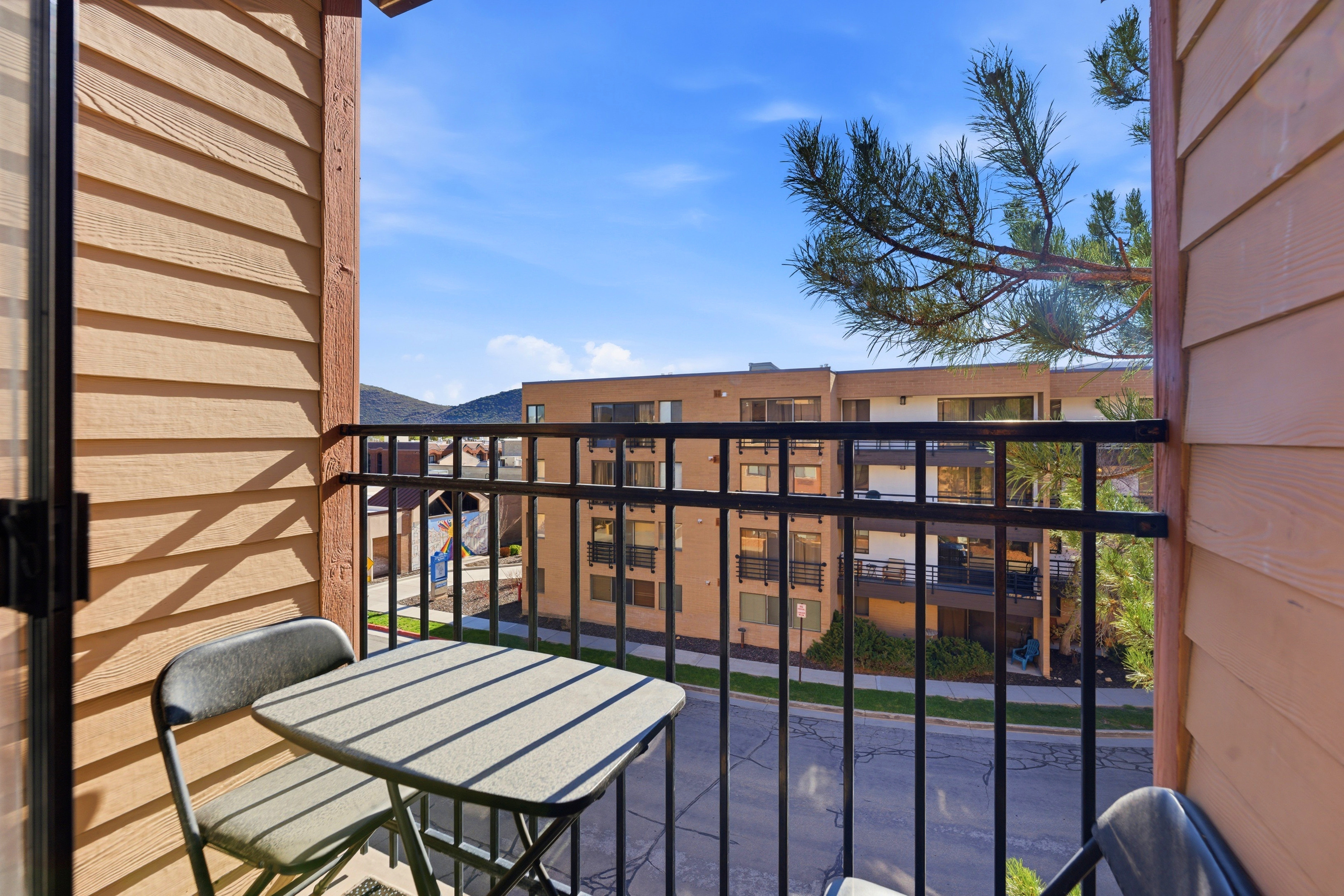 Private balcony featuring horizontal wood-finish siding and black metal railings