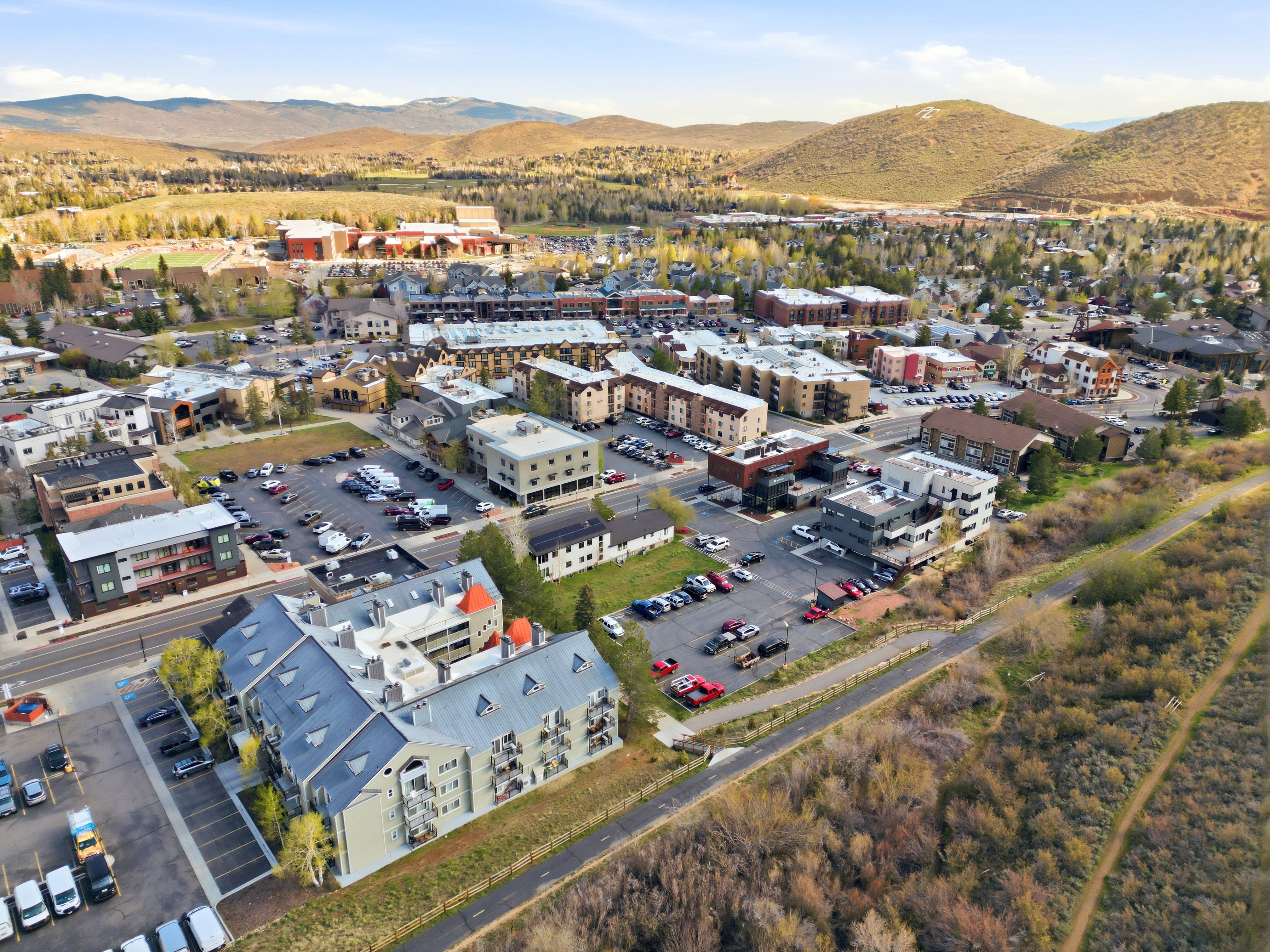 Aerial perspective of a mixed-use commercial and residential district, featuring multi-story buildings with various architectural styles