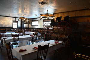 Spacious dining area featuring wood-finish flooring, pressed metal ceiling, and wall paneling