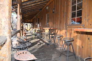 Covered porch with exposed log beam construction and wood paneling