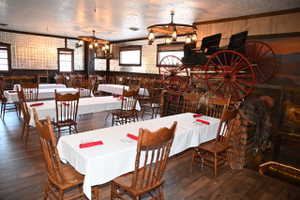 Spacious dining area featuring wood-finish flooring, pressed tin wall panels, and exposed wood beams