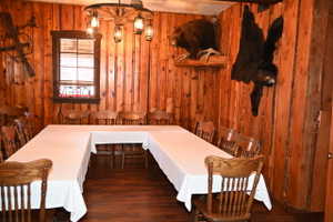 Interior room featuring natural wood paneling, wood-finish flooring, and a unique wagon wheel chandelier with lantern-style lighting