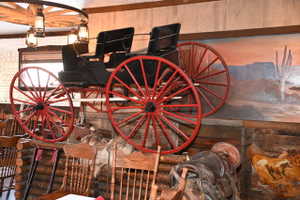 Wood-paneled interior featuring a wagon wheel chandelier with lantern-style lighting
