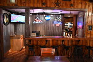 Custom bar area featuring wood paneling and a corrugated metal accent wall