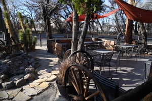 Outdoor patio space featuring multiple seating areas, flagstone pathway, and shade canopies