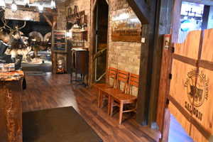 Wood-finish flooring extending from the entrance, exposed brick wall accents, and robust timber structural elements