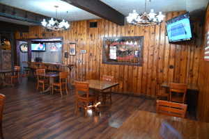 Spacious interior featuring wood-finish flooring, wood-paneled walls, and exposed ceiling beams