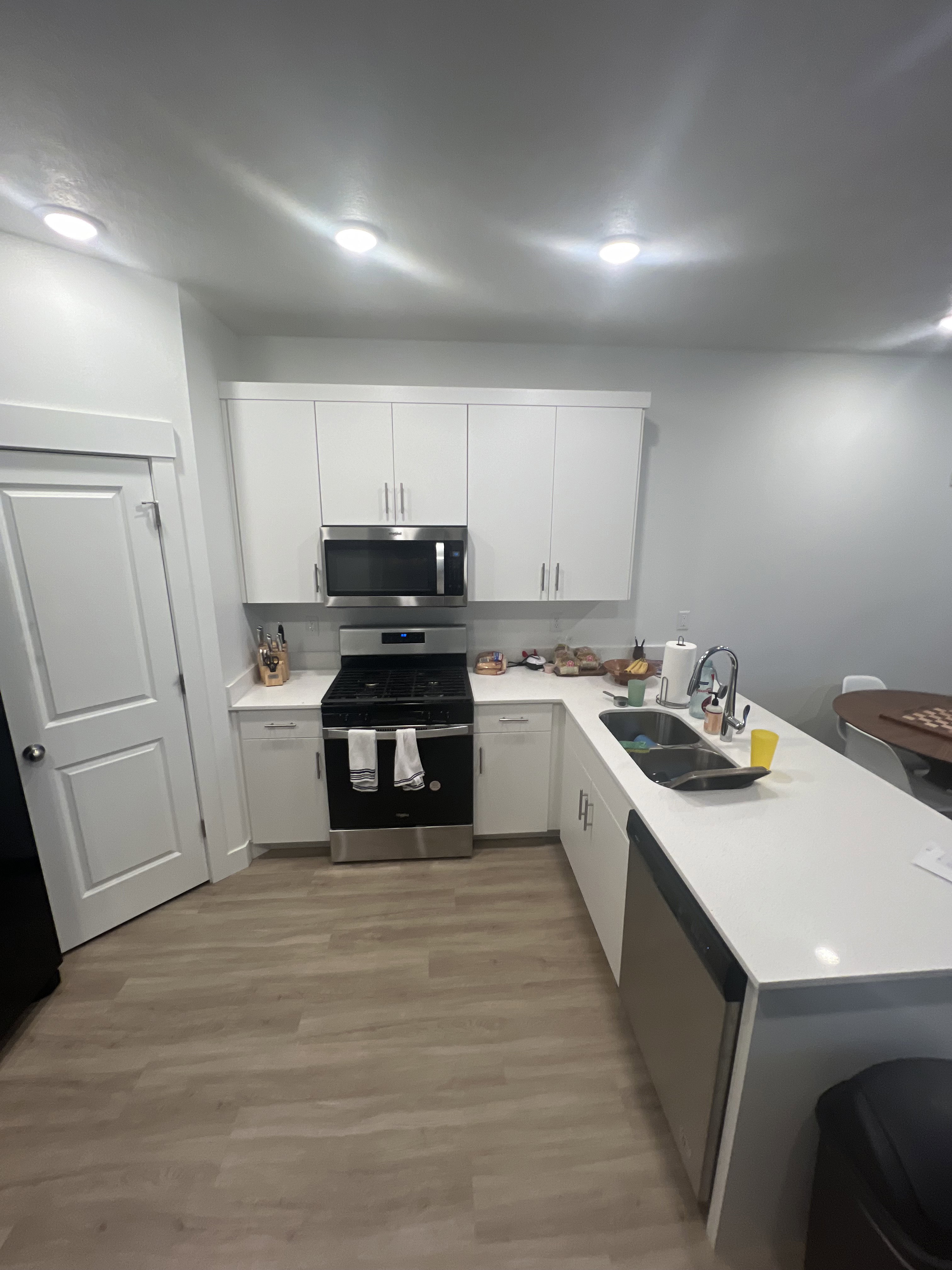 Kitchen featuring light wood-finish flooring, white cabinetry, white countertops, and recessed lighting