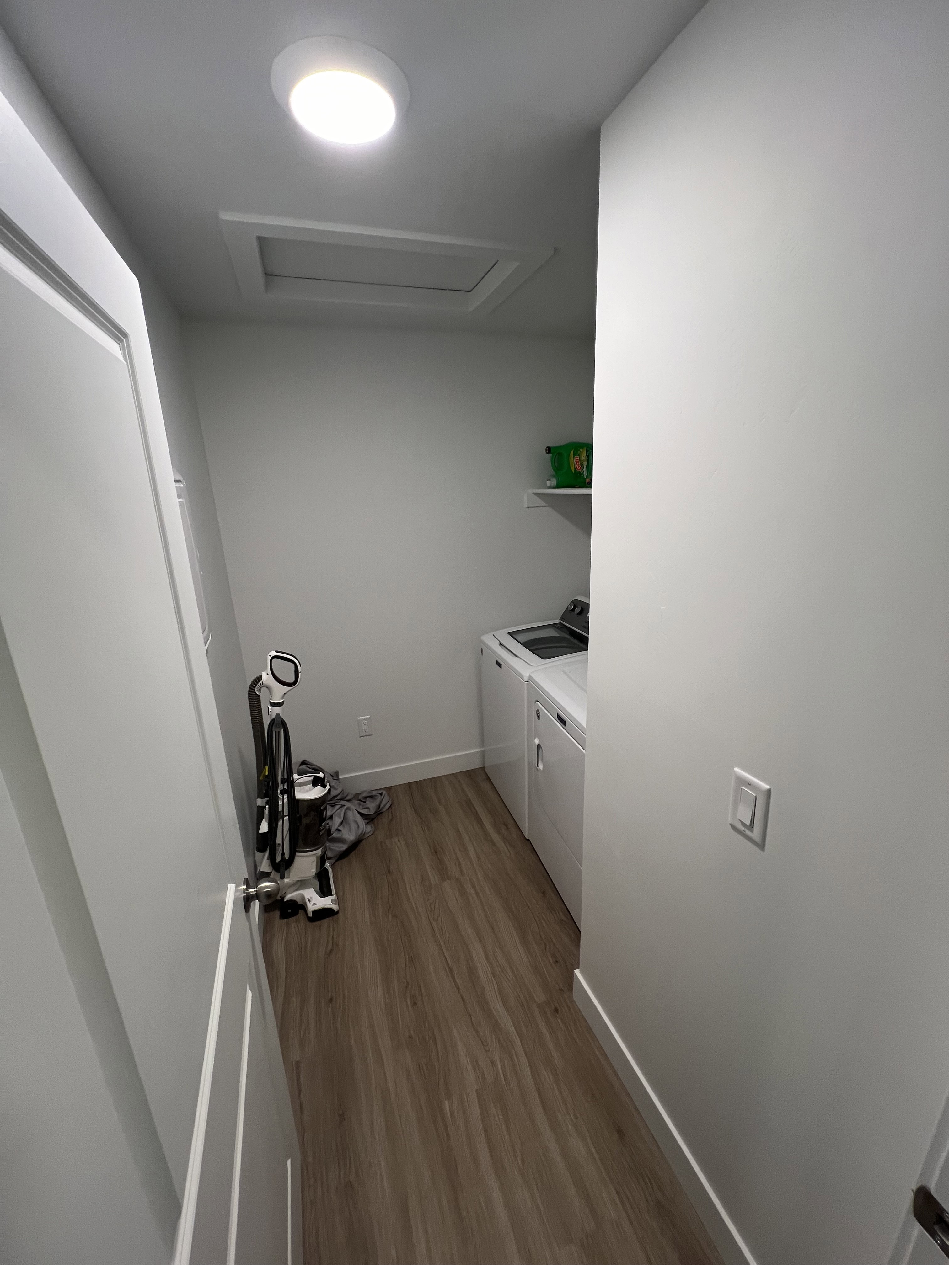Dedicated laundry area featuring wood-finish flooring, white walls, and a recessed ceiling light