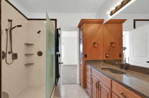 Master bathroom with granite-style countertop, integrated sink, dual shower heads and bronze-finish fixtures