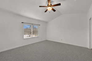 Spacious master bedroom featuring vaulted ceilings, a ceiling fan with integrated lighting, and a window with horizontal blinds