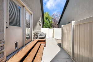 Private side yard with a concrete walkway and light-toned fencing