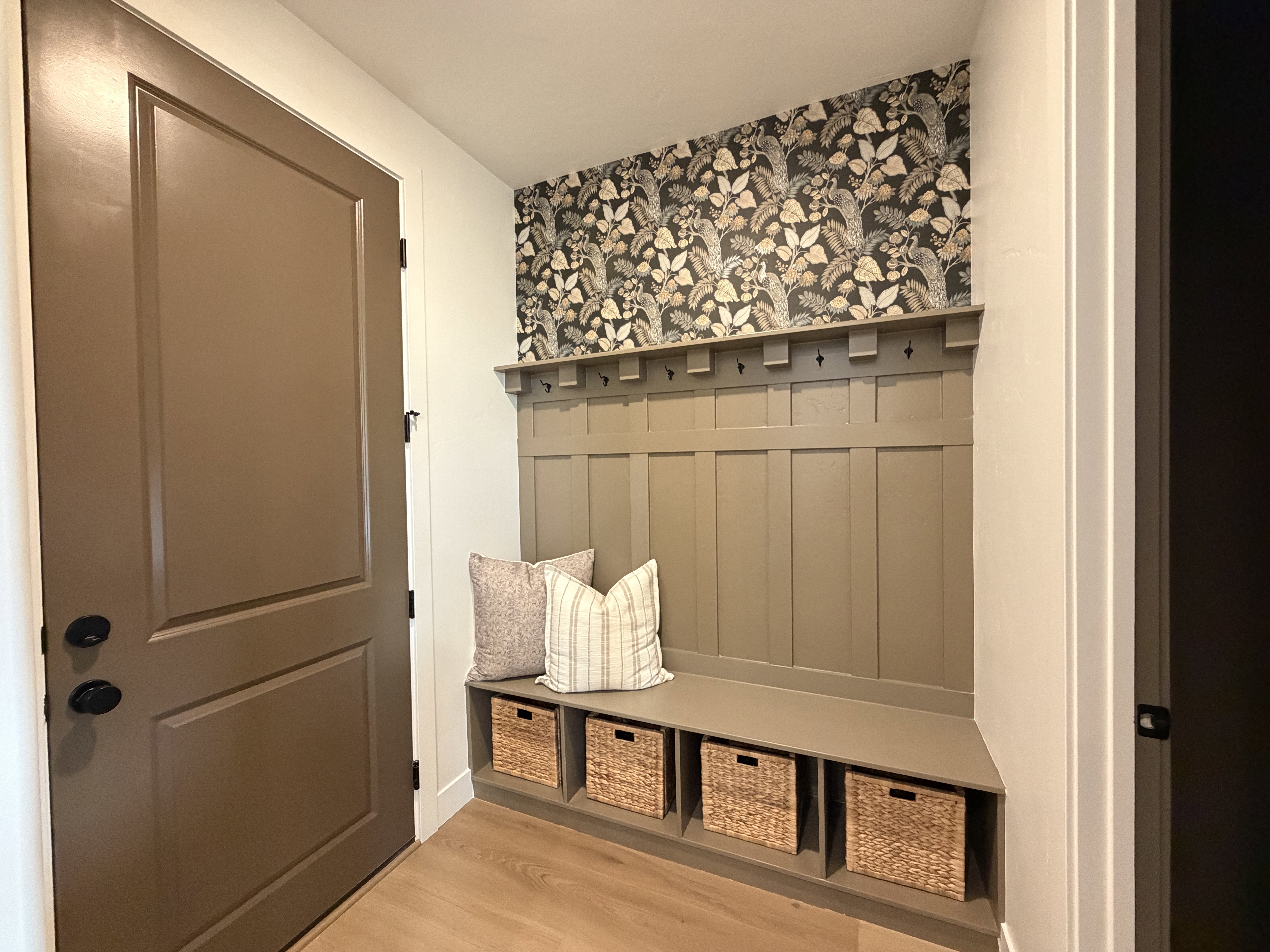 Mudroom area featuring built-in bench seating with cubbies and upper coat hooks