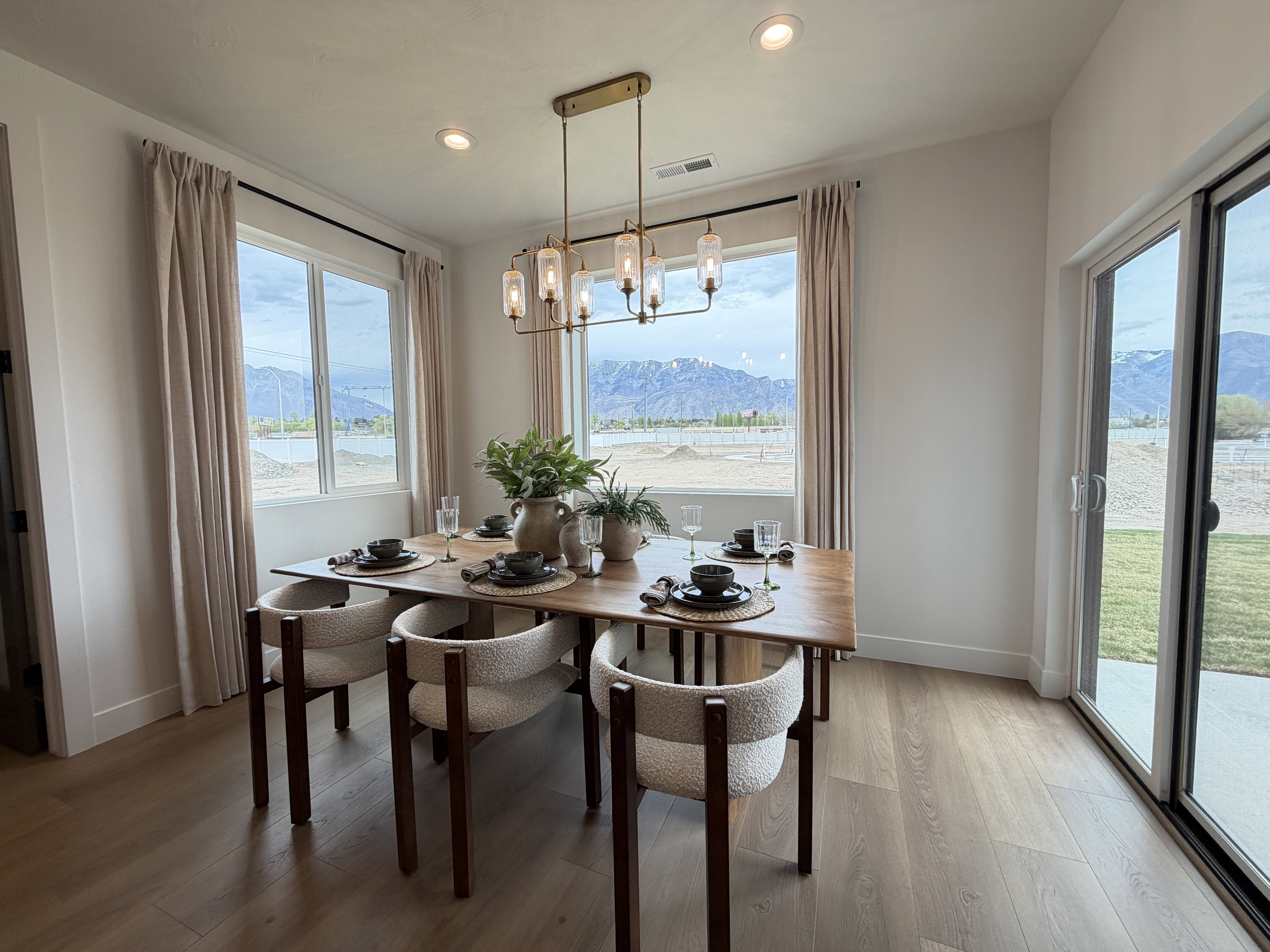 Open concept dining area featuring wood-finish flooring, a contemporary chandelier, recessed lighting, and expansive windows