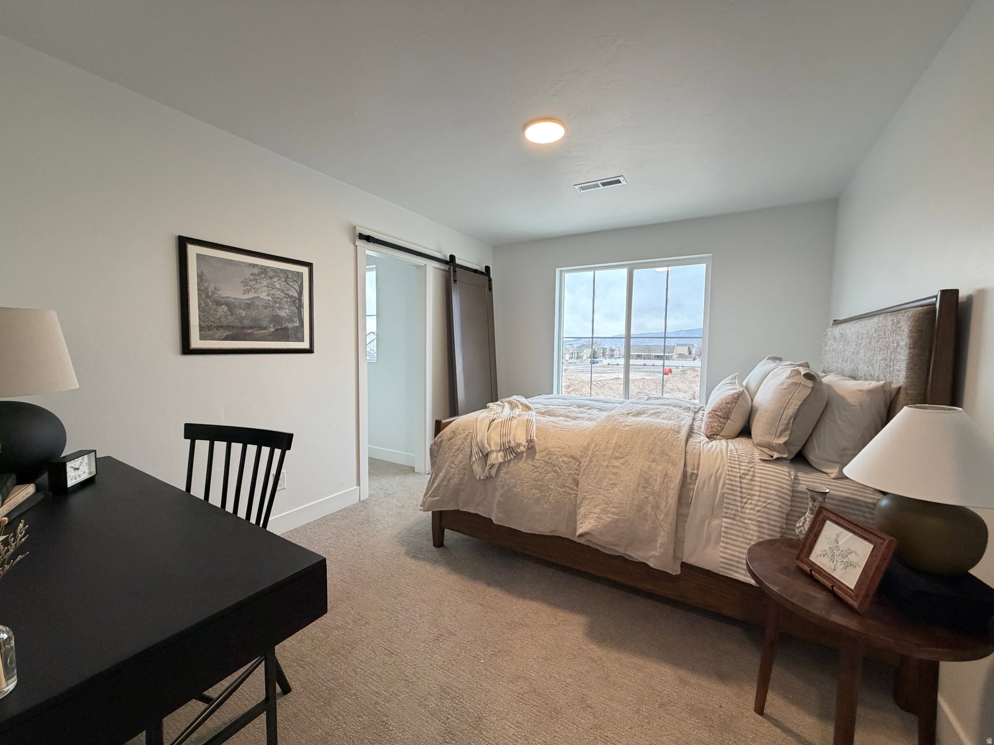 Carpeted bedroom featuring a sliding barn door, recessed ceiling lighting, a large window, and white trim