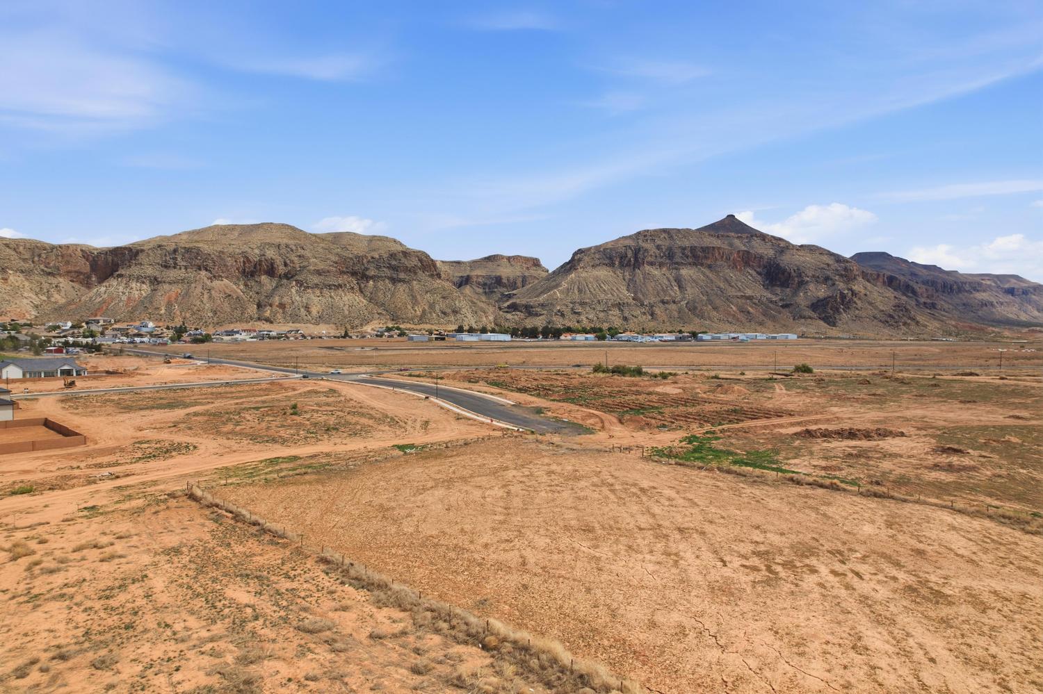 Expansive desert terrain with distant mountain formations under a clear sky