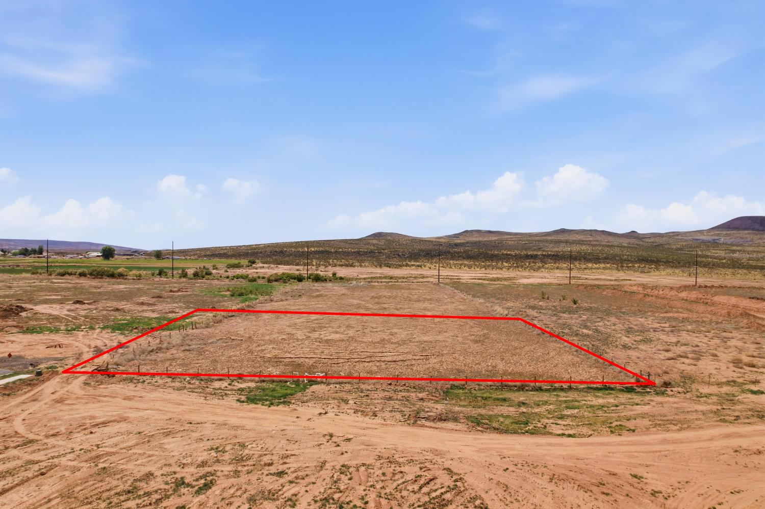 Expansive undeveloped lot featuring a defined boundary and distant mountainous terrain