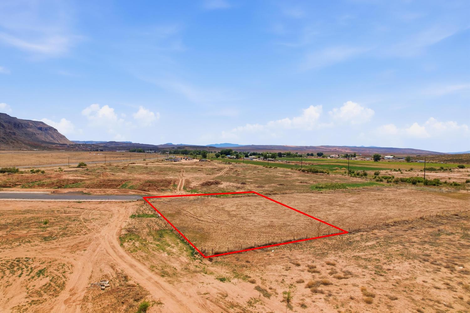 Expansive parcel of undeveloped land, featuring a flat topography and distant mountain backdrop