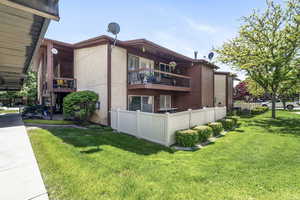 Multi-level exterior featuring balconies, a patio, and a white privacy fence