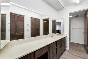 Bathroom vanity with a large countertop, integrated sink, and wood-finish cabinetry