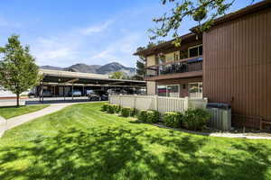 Multi-level building with vertical brown siding and a balcony