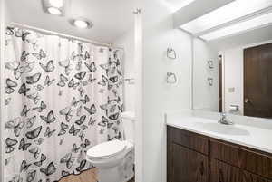 Bathroom featuring a wood-finish vanity with a white countertop and integrated sink
