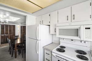 Kitchen featuring white cabinetry, coordinating appliances, and light-toned countertops