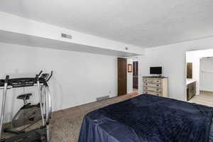 Carpeted room with white walls, a wood-finish door, and baseboard heating