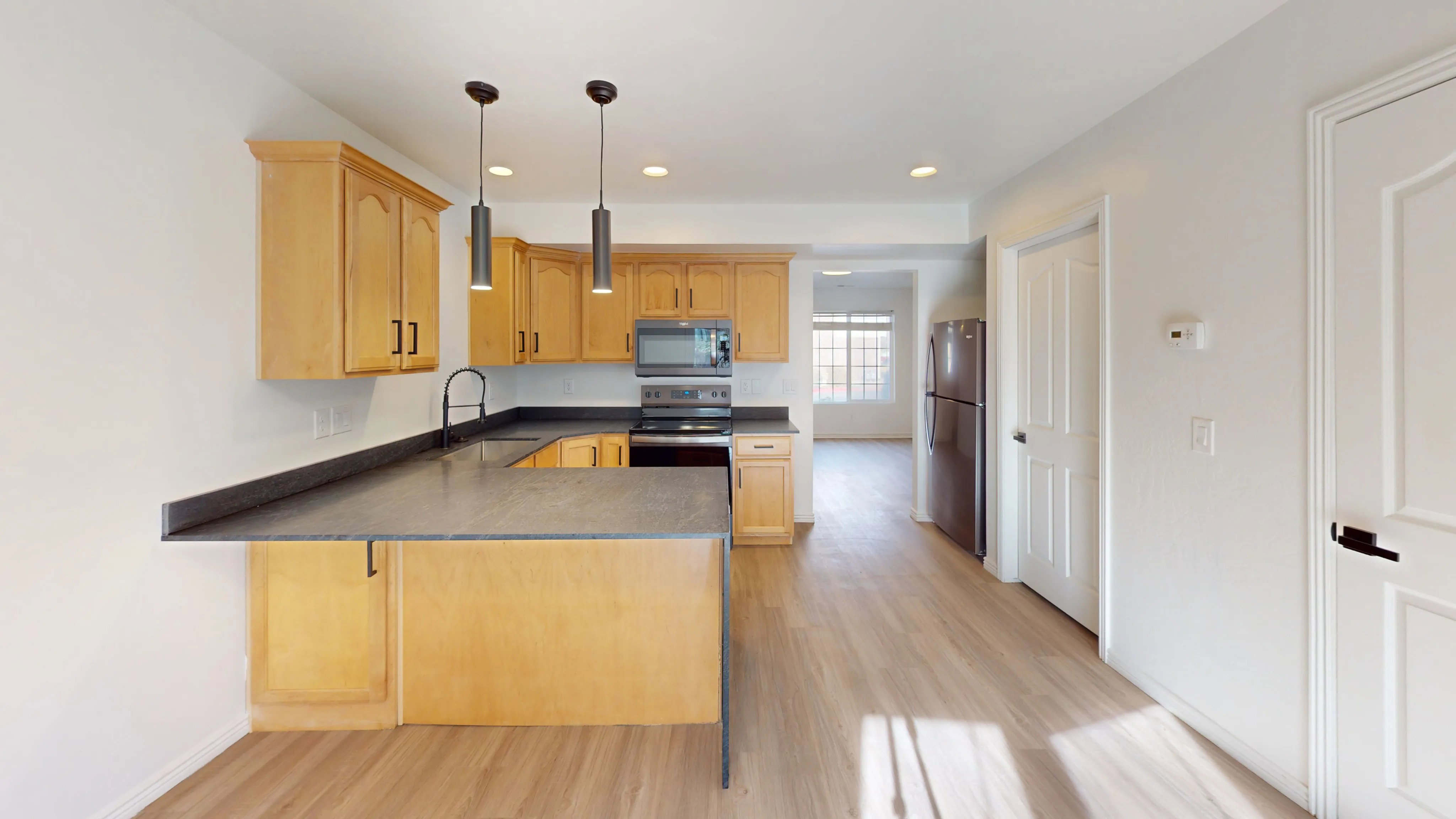 Kitchen featuring wood-finish cabinetry, dark countertops, and stainless steel appliances