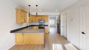 Kitchen featuring wood-finish cabinetry, dark countertops, and stainless steel appliances