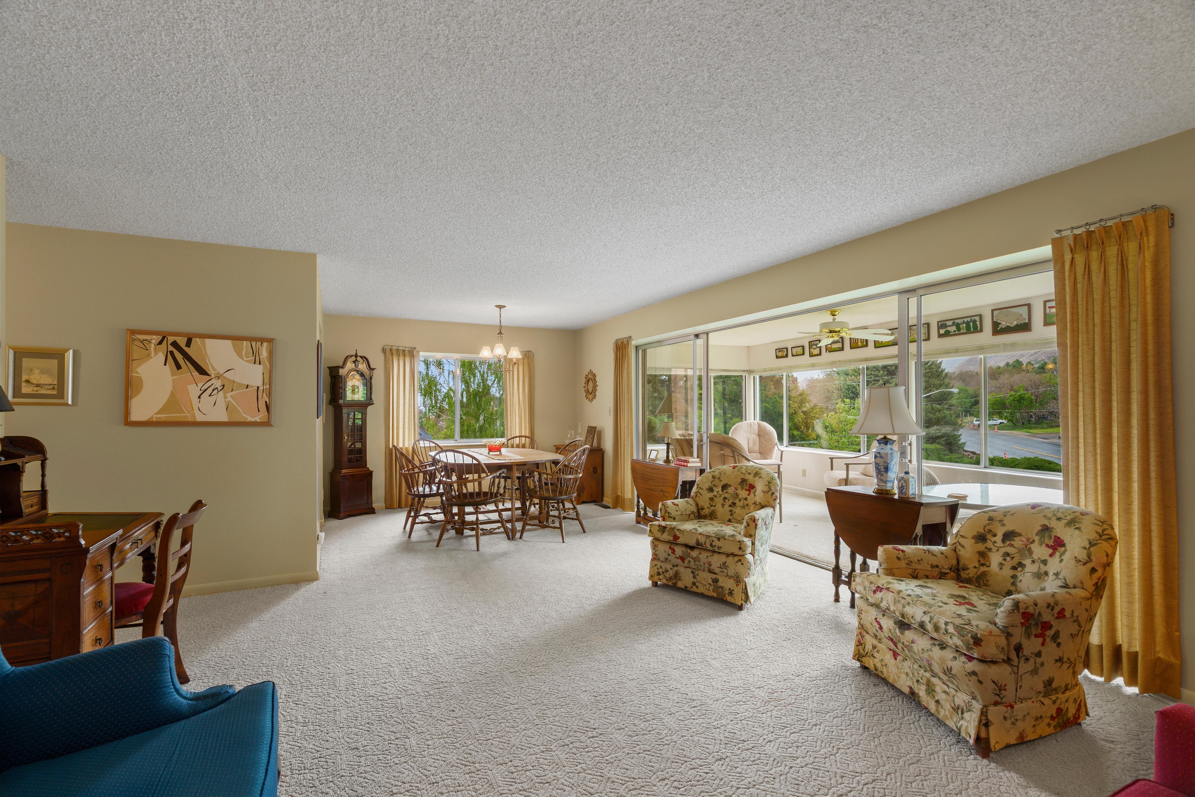 Spacious living area with light-colored carpeting and neutral wall tones