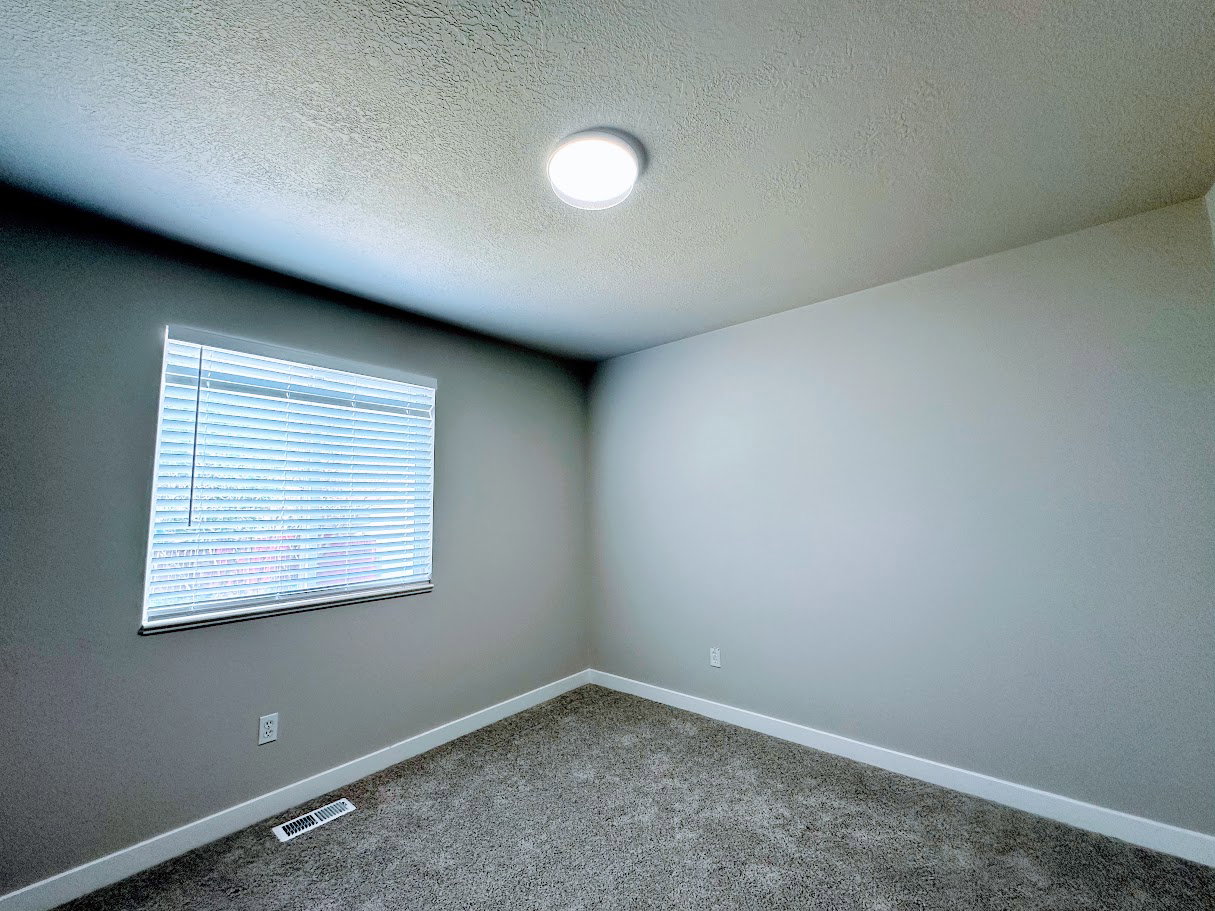 Room featuring textured ceiling, recessed ceiling light, wall-to-wall carpeting, window with blinds, and painted walls