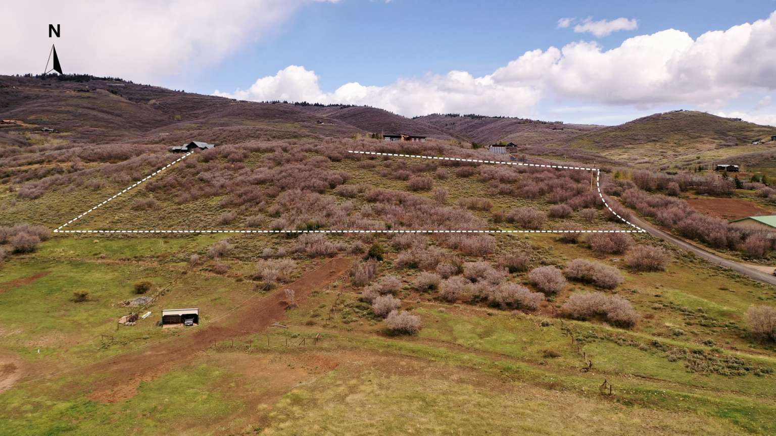 Expansive undeveloped land parcel featuring varied topography, natural shrubbery, and a defined boundary