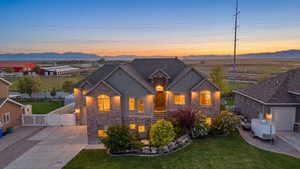 View of front of home with a gate, a mountain view, driveway, and stone siding