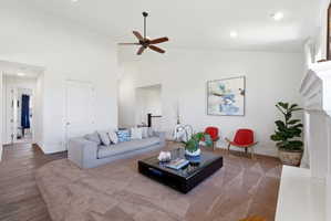 Living area featuring recessed lighting, a ceiling fan, wood-type flooring, lofted ceiling, and a fireplace