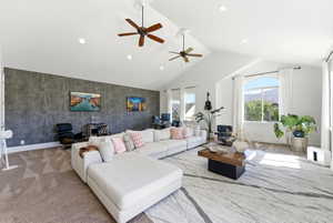 Living room featuring a high ceiling, recessed lighting, ceiling fan, carpet flooring, and an accent wall
